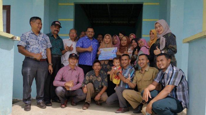 Anggota DPR Aceh asal Aceh Tamiang dan Kota Langsa, Asrizal H Asnawi, menyerahkan 1 tiket umrah gratis kepada Marlia S.Pd.I, guru bakti atau honorer di SMPN 6 Bendahara, Aceh Tamiang